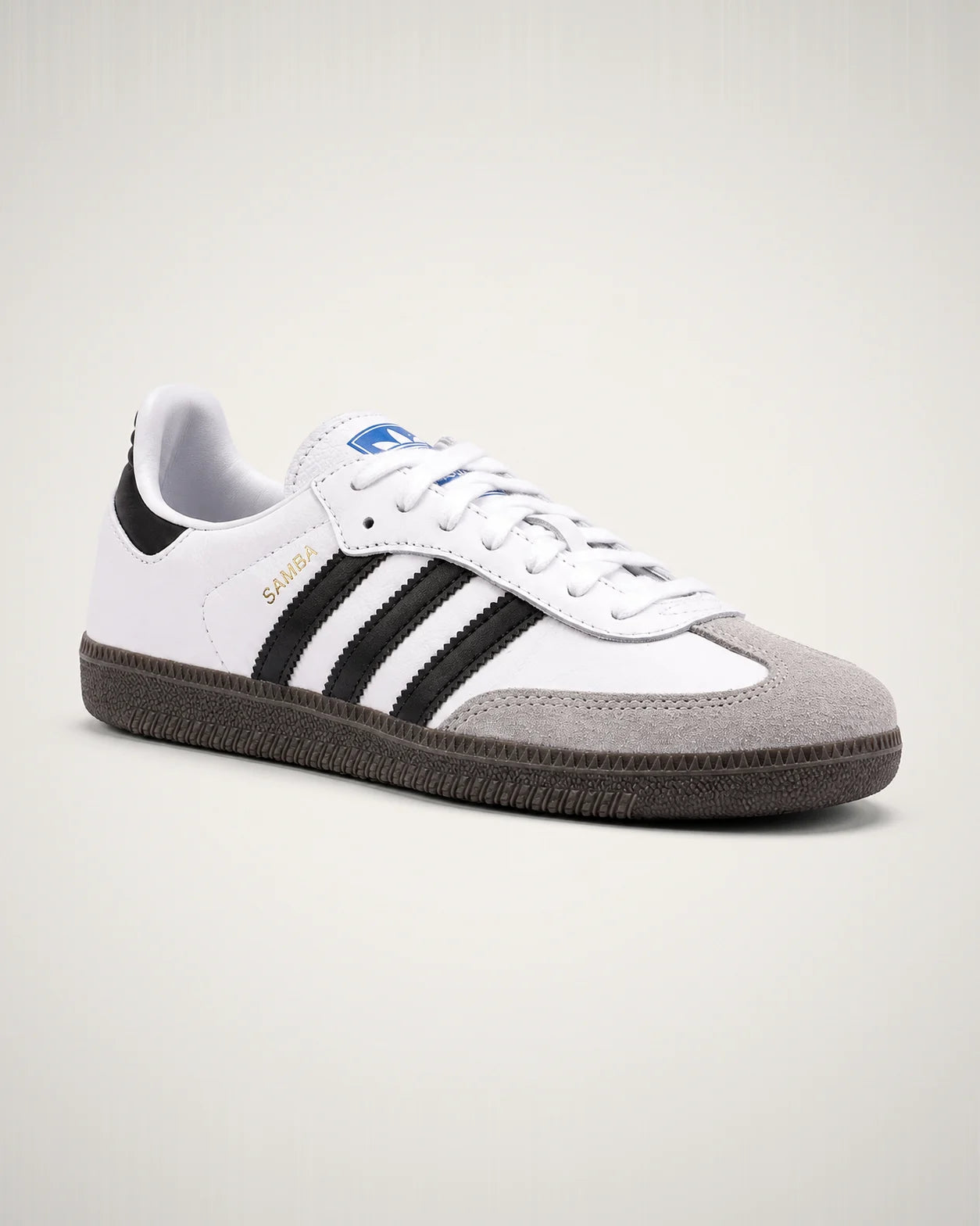 Samba OG blanco con franjas negras, puntera T de gamuza gris y suela gum oscura.