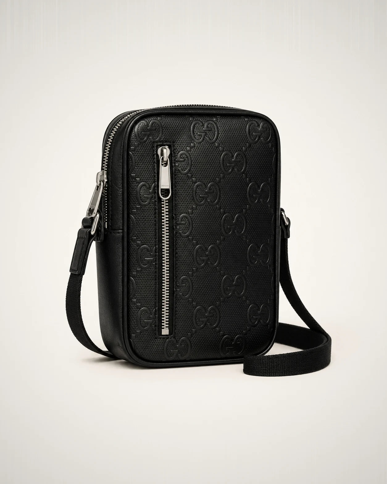 Bolsa crossbody compacta negra con monograma tonal.