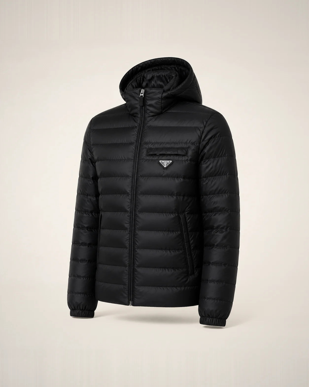 Puffer negra de Re-Nylon con capucha, cámaras estrechas y badge triangular.