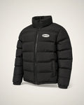 Puffer negra de cuello alto con badge ovalado blanco y cámaras acolchadas anchas.