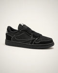 Jordan 1 Low negro con Swoosh invertido, gamuza tonal y costuras blancas de alto contraste.